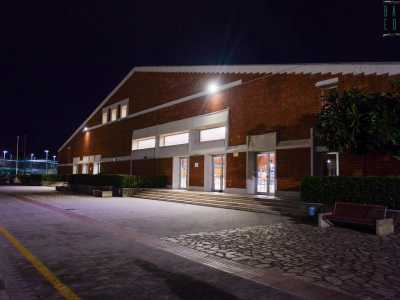 Superiamo cos� la porta scorrevole di ingresso e imbocchiamo poi uno stretto corridoio che ci porta a un ampio spiazzo delimitato a sinistra dal mare. In fondo si staglia il palazzetto, in mattoni arancioni e tetto a spioventi